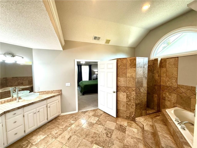 4531 Anderson St, Shawnee, KS 66226 - bathroom with a textured ceiling, ensuite bathroom, a garden tub, vanity, and lofted ceiling