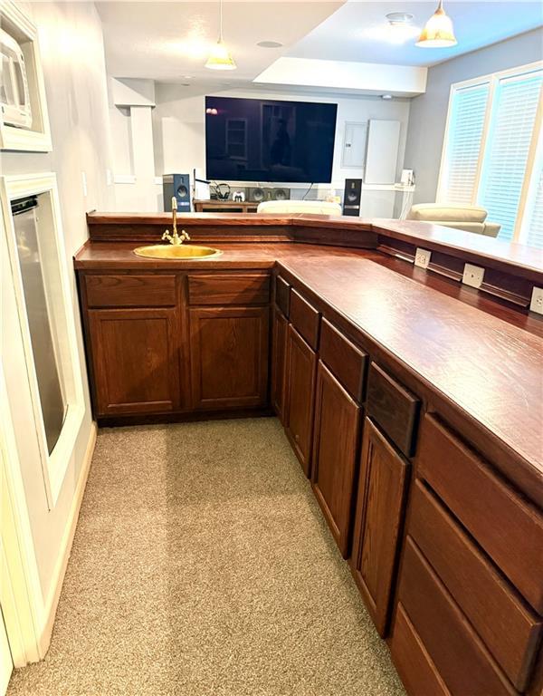 4531 Anderson St, Shawnee, KS 66226 - kitchen featuring dark countertops, open floor plan, decorative light fixtures, and dark brown cabinets