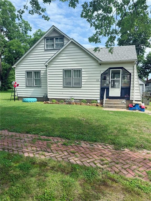 704 W 2nd St, Coffeyville, KS 67337 - view of front of property featuring entry steps and a front yard