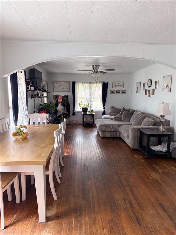 704 W 2nd St, Coffeyville, KS 67337 - dining space with hardwood / wood-style floors, ceiling fan, and arched walkways