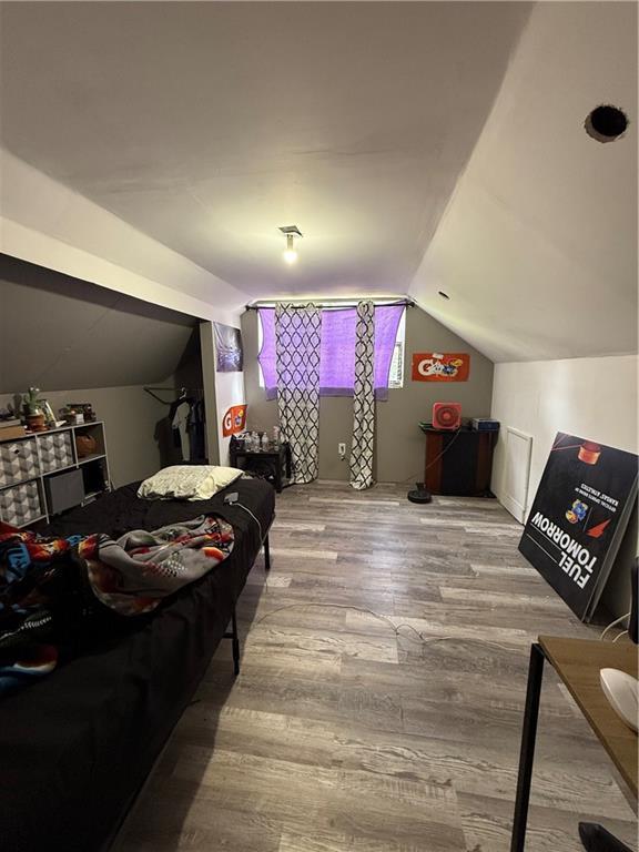 704 W 2nd St, Coffeyville, KS 67337 - bedroom featuring vaulted ceiling and wood finished floors