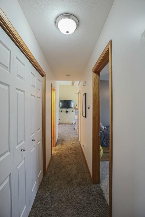 127 Hondo St, Lathrop, MO 64465 - hallway with carpet flooring and a textured ceiling