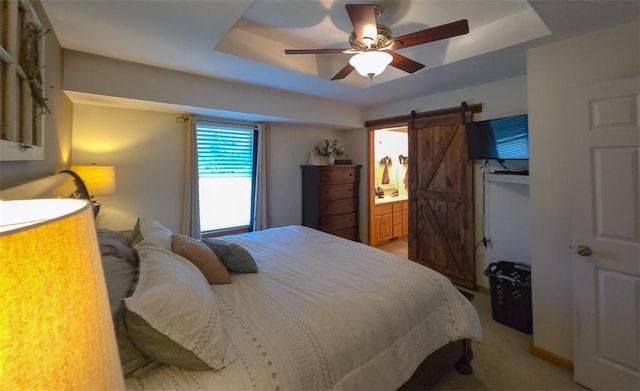 127 Hondo St, Lathrop, MO 64465 - bedroom with a raised ceiling, a barn door, ceiling fan, connected bathroom, and light colored carpet