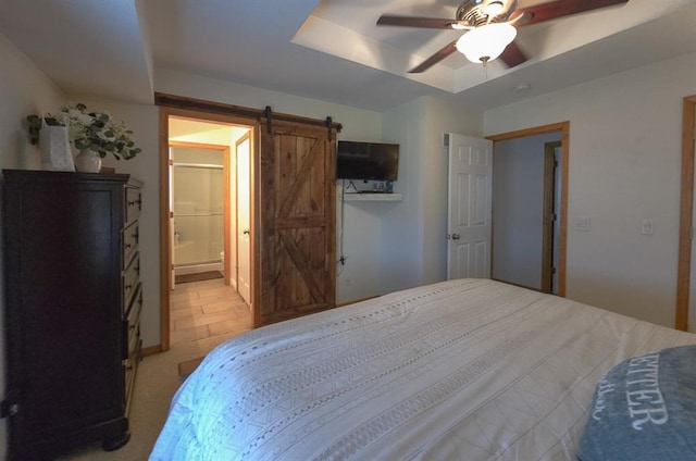 127 Hondo St, Lathrop, MO 64465 - bedroom featuring a tray ceiling, a barn door, ceiling fan, and ensuite bath