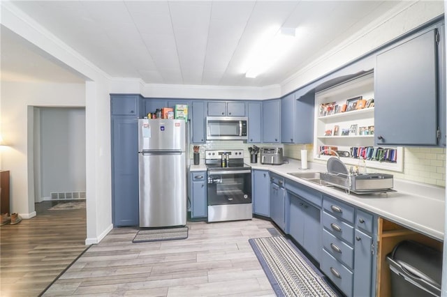 516 W 7th St, Carrollton, MO 64633 - kitchen featuring appliances with stainless steel finishes, blue cabinetry, open shelves, light wood-type flooring, and light countertops