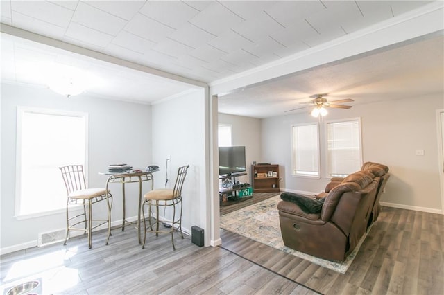 516 W 7th St, Carrollton, MO 64633 - living room with wood finished floors, ceiling fan, and ornamental molding