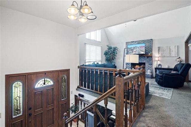 11579 Earnshaw St, Overland Park, KS 66210 - carpeted foyer with lofted ceiling, a chandelier, healthy amount of natural light, and a brick fireplace