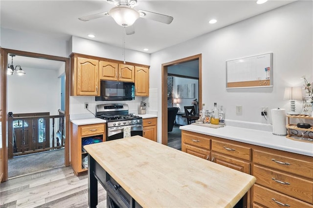11579 Earnshaw St, Overland Park, KS 66210 - kitchen with stainless steel range with gas stovetop, black microwave, light wood-type flooring, light countertops, and a ceiling fan