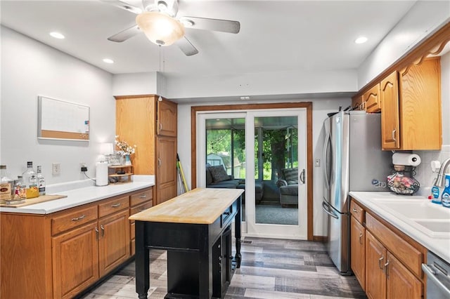 11579 Earnshaw St, Overland Park, KS 66210 - kitchen with stainless steel appliances, light wood-style floors, ceiling fan, wooden counters, and brown cabinets