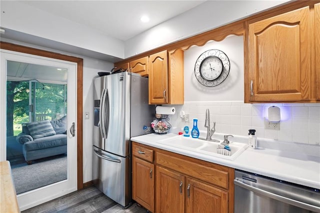 11579 Earnshaw St, Overland Park, KS 66210 - kitchen with stainless steel appliances, wood finished floors, light countertops, backsplash, and brown cabinetry