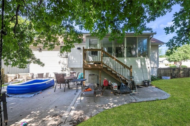 11579 Earnshaw St, Overland Park, KS 66210 - back of property with a patio area, a sunroom, and stairway