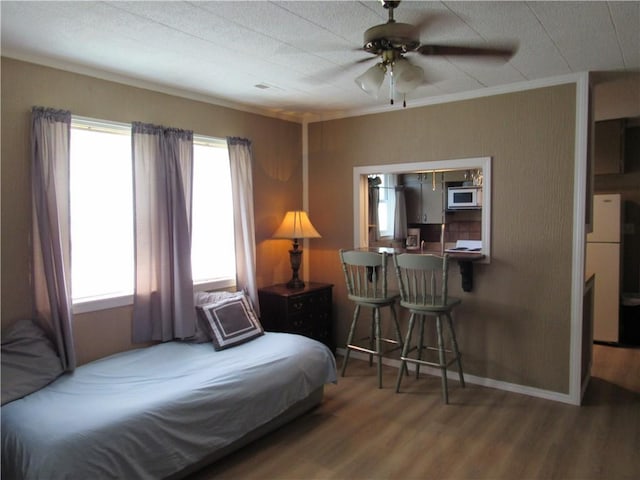 706 W 10th St, Sedalia, MO 65301 - bedroom featuring wood finished floors, crown molding, freestanding refrigerator, and a ceiling fan