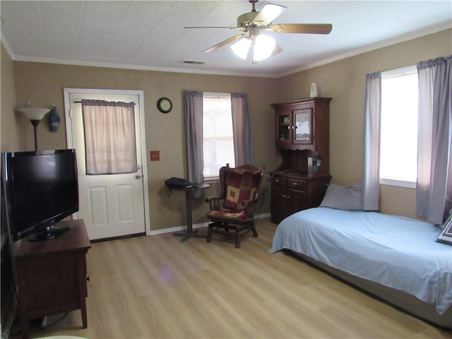 706 W 10th St, Sedalia, MO 65301 - bedroom with light wood-type flooring, ornamental molding, multiple windows, and a ceiling fan