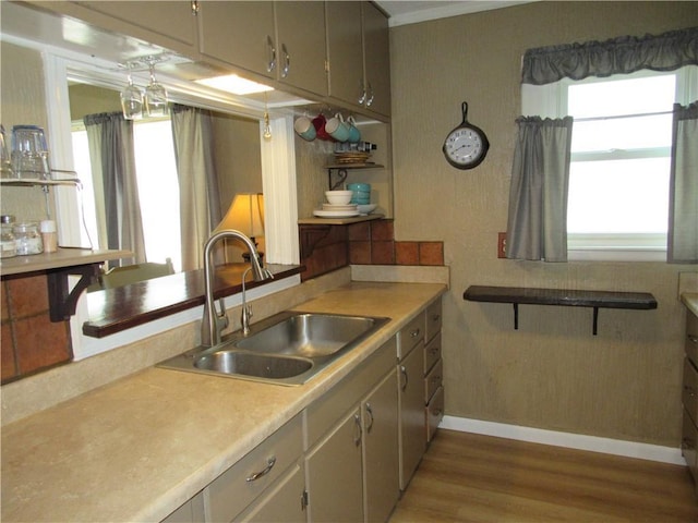 706 W 10th St, Sedalia, MO 65301 - kitchen with wood finished floors, light countertops, open shelves, and crown molding