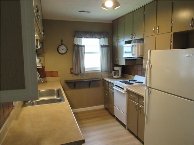 706 W 10th St, Sedalia, MO 65301 - kitchen featuring white appliances, light wood finished floors, light countertops, and tasteful backsplash
