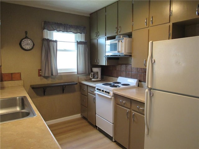706 W 10th St, Sedalia, MO 65301 - kitchen featuring white appliances, light wood finished floors, light countertops, and backsplash