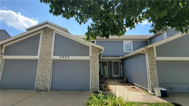 2604 S Peck Ct Unit B, Independence, MO 64055 - mid-century inspired home with an attached garage, driveway, and stone siding