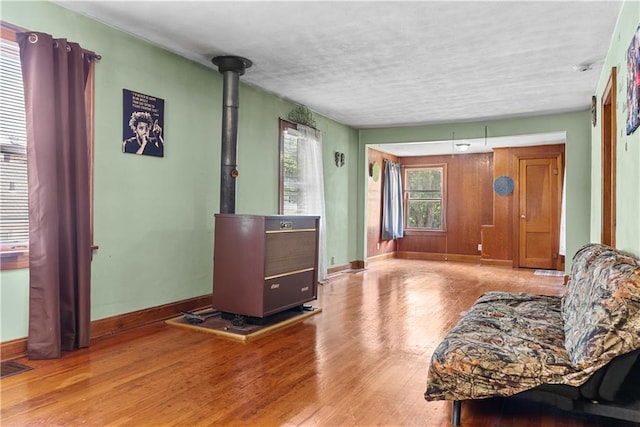1234 S Pearl St, Independence, MO 64055 - living area featuring a wood stove, wood finished floors, and a textured ceiling