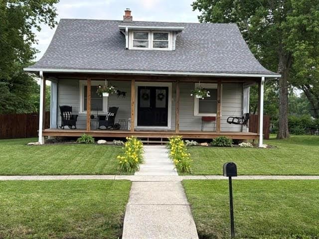 383 E Broadway St, Peculiar, MO 64078 - country-style home featuring a porch, a chimney, and a shingled roof