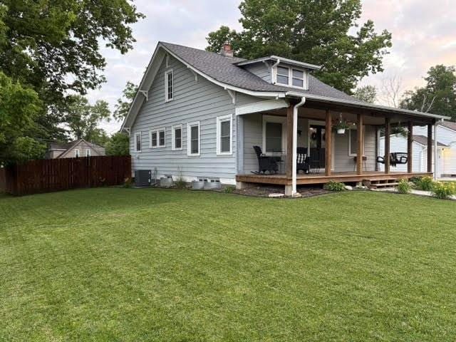 383 E Broadway St, Peculiar, MO 64078 - back of house with a chimney, covered porch, and a shingled roof
