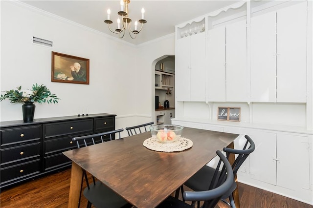 6347 Sni A Bar Rd, Kansas City, MO 64129 - dining room with dark wood-style flooring, ornamental molding, a chandelier, and arched walkways
