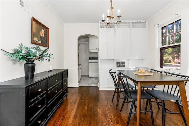 6347 Sni A Bar Rd, Kansas City, MO 64129 - dining space featuring dark wood-type flooring, arched walkways, crown molding, and a chandelier