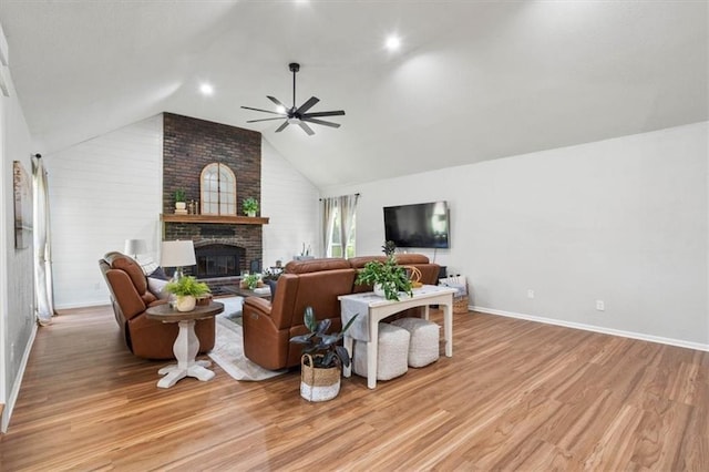 1803 N Jeter Rd, Raymore, MO 64083 - living area with a fireplace, a ceiling fan, light wood finished floors, and vaulted ceiling