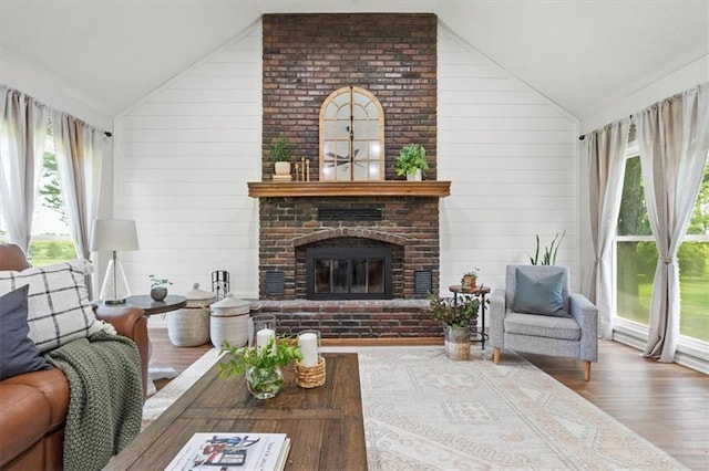 1803 N Jeter Rd, Raymore, MO 64083 - living area featuring vaulted ceiling, wood finished floors, plenty of natural light, a fireplace, and wood walls