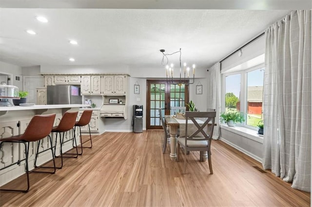 1803 N Jeter Rd, Raymore, MO 64083 - dining space featuring light wood finished floors, recessed lighting, french doors, and a chandelier