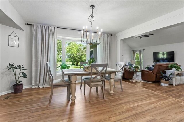 1803 N Jeter Rd, Raymore, MO 64083 - dining space featuring a chandelier, light wood-style floors, a textured ceiling, and ceiling fan