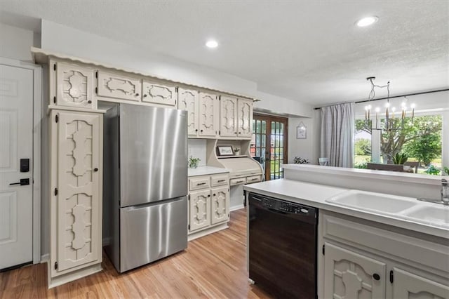 1803 N Jeter Rd, Raymore, MO 64083 - kitchen featuring freestanding refrigerator, dishwasher, a textured ceiling, light wood-type flooring, and recessed lighting