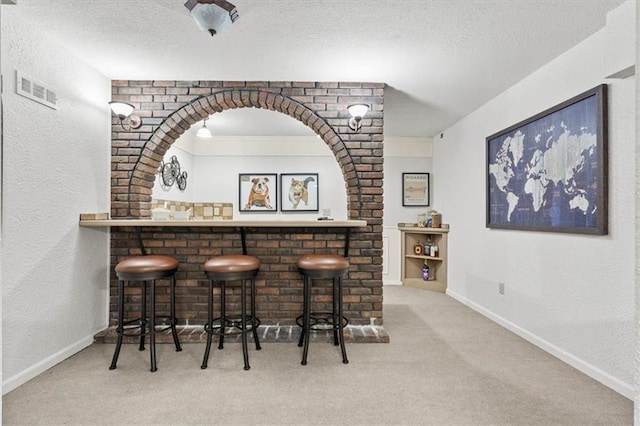 1803 N Jeter Rd, Raymore, MO 64083 - indoor dry bar with carpet flooring, a textured ceiling, and a textured wall