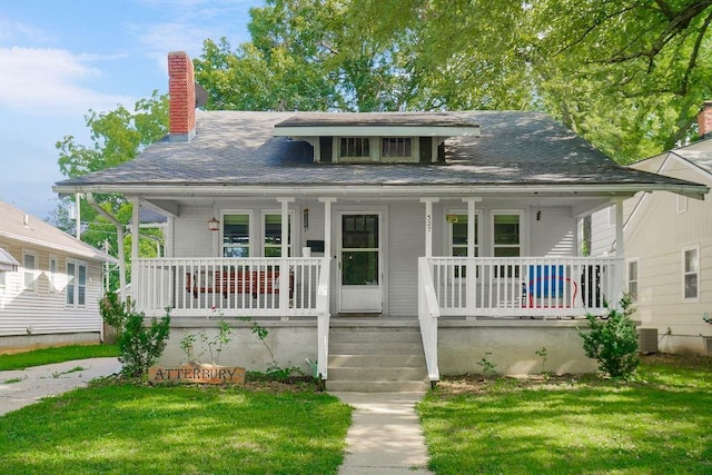 327 Parker Ave, Osawatomie, KS 66064 - view of front of house featuring a porch, a front lawn, a chimney, and roof with shingles