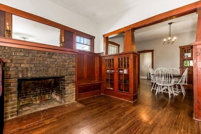 327 Parker Ave, Osawatomie, KS 66064 - living area featuring wood finished floors, a fireplace, and a chandelier