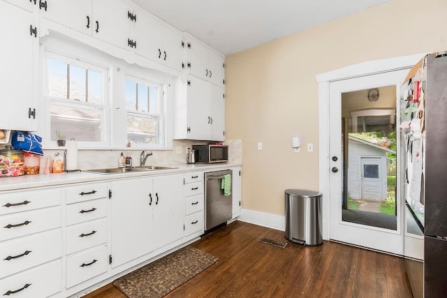 327 Parker Ave, Osawatomie, KS 66064 - kitchen with stainless steel appliances, dark wood-style floors, light countertops, white cabinetry, and decorative backsplash