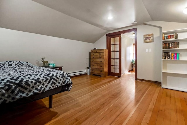 327 Parker Ave, Osawatomie, KS 66064 - bedroom featuring a baseboard heating unit, light wood-style flooring, and vaulted ceiling
