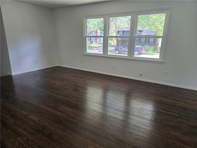 6302 E 120th Ter, Grandview, MO 64030 - empty room with dark wood-style flooring and baseboards