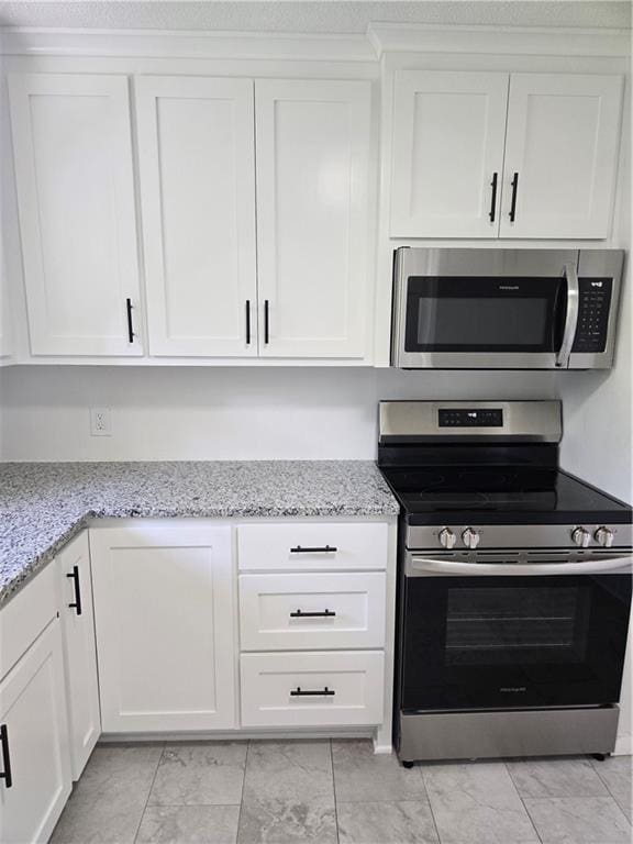 6302 E 120th Ter, Grandview, MO 64030 - kitchen with appliances with stainless steel finishes, white cabinetry, and light stone counters
