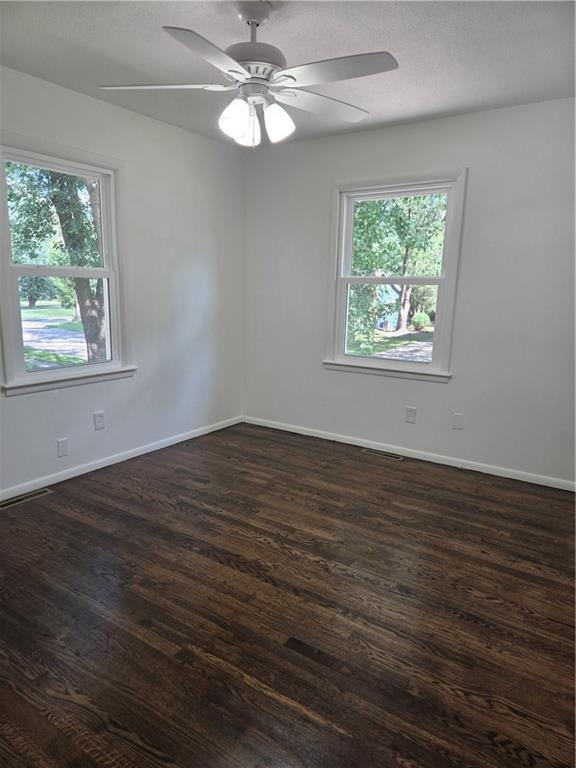 6302 E 120th Ter, Grandview, MO 64030 - spare room with dark wood-type flooring and ceiling fan