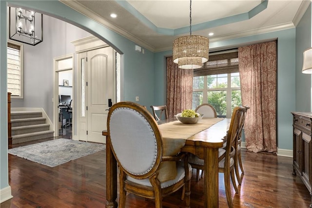 9445 W 157th Pl, Overland Park, KS 66221 - dining space featuring a chandelier, arched walkways, dark wood-style flooring, ornamental molding, and stairway