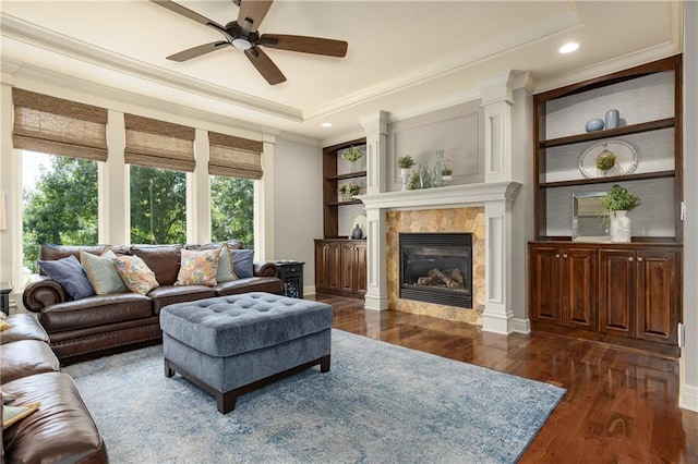 9445 W 157th Pl, Overland Park, KS 66221 - living area featuring crown molding, a ceiling fan, dark wood-style floors, a raised ceiling, and a glass covered fireplace