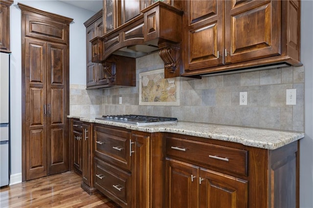 9445 W 157th Pl, Overland Park, KS 66221 - kitchen with stainless steel gas stovetop, light wood-type flooring, tasteful backsplash, and light stone counters