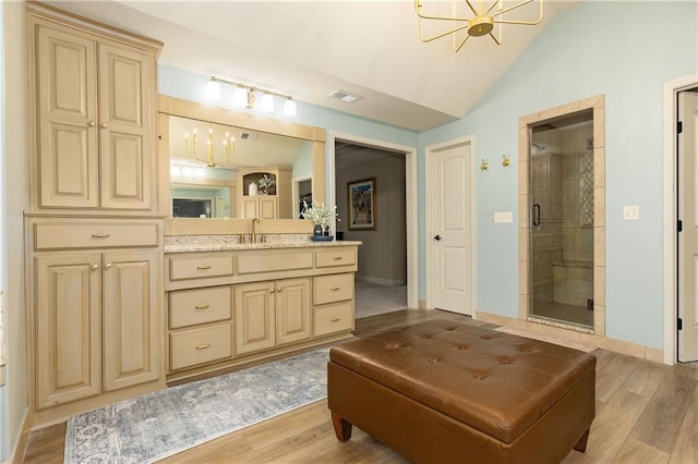 9445 W 157th Pl, Overland Park, KS 66221 - full bath with vanity, a shower stall, wood finished floors, vaulted ceiling, and a chandelier