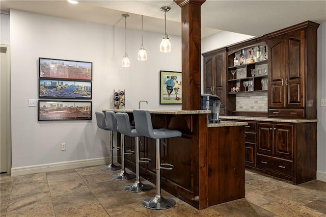9445 W 157th Pl, Overland Park, KS 66221 - indoor wet bar with stone tile floors, decorative backsplash, and decorative light fixtures