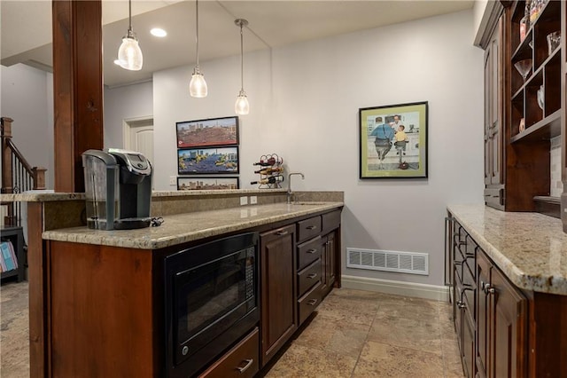 9445 W 157th Pl, Overland Park, KS 66221 - kitchen with black microwave, a peninsula, light stone counters, decorative light fixtures, and light stone finish flooring