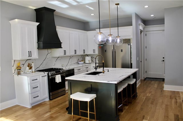 5443 N 101st Ter, Kansas City, KS 66109 - kitchen with appliances with stainless steel finishes, custom range hood, light wood finished floors, a kitchen breakfast bar, and an island with sink