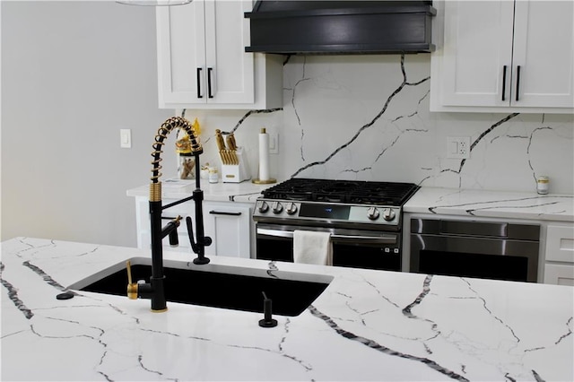 5443 N 101st Ter, Kansas City, KS 66109 - kitchen with extractor fan, stainless steel gas range, wall oven, and white cabinetry