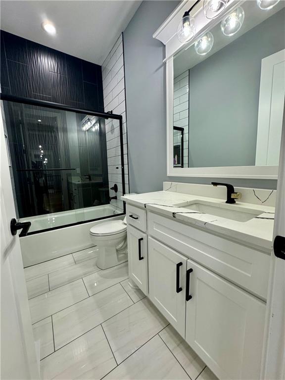5443 N 101st Ter, Kansas City, KS 66109 - full bath with shower / bath combination with glass door, vanity, and marble finish flooring