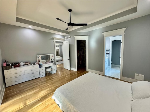 5443 N 101st Ter, Kansas City, KS 66109 - bedroom with a raised ceiling, light wood-style floors, recessed lighting, ensuite bath, and a ceiling fan