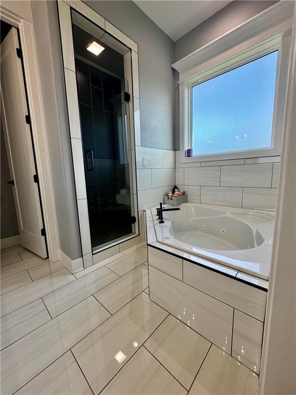 5443 N 101st Ter, Kansas City, KS 66109 - bathroom with a jetted tub, a stall shower, and tile patterned flooring